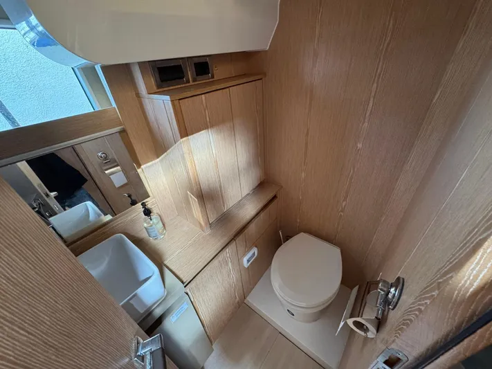 Sealine C530 Yacht Photos Pics Compact bathroom in 2017 Sealine C530 yacht with wooden cabinetry and modern fixtures.