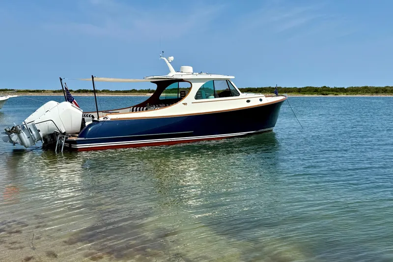Carol I Yacht Photos Pics 2024 Hinckley 35 boat anchored in clear, shallow water under a blue sky.