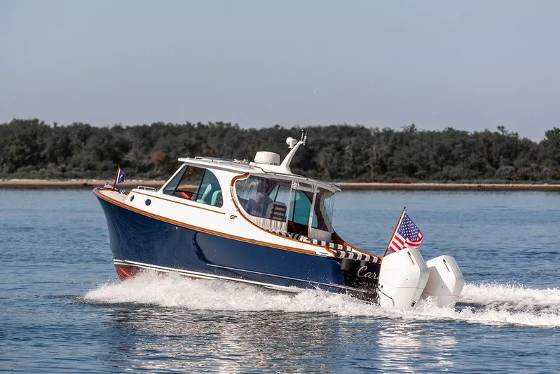 Carol I Yacht Photos Pics 2024 Hinckley 35 boat cruising on water with American flag, scenic background.