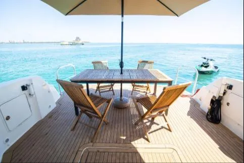 Salty Pause Yacht Photos Pics 2005 Sea Ray 420 Sedan Bridge yacht deck with chairs and table, ocean view.