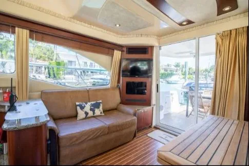 Salty Pause Yacht Photos Pics Interior of 2005 Sea Ray 420 Sedan Bridge yacht with sofa and large windows.