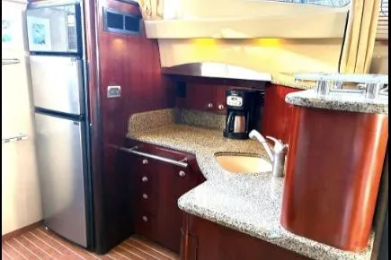 Salty Pause Yacht Photos Pics 2005 Sea Ray 420 Sedan Bridge kitchen with modern appliances and wood cabinetry.