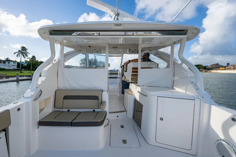  Yacht Photos Pics 2019 Pursuit DC 365 Dual Console boat interior with seating and helm, docked by water.