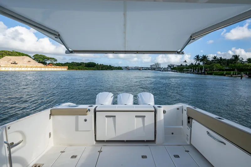  Yacht Photos Pics 2019 Pursuit DC 365 Dual Console boat on scenic waterway with lush greenery.