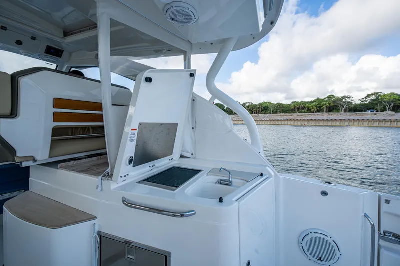  Yacht Photos Pics 2019 Pursuit DC 365 Dual Console boat interior with sink and seating, near water.