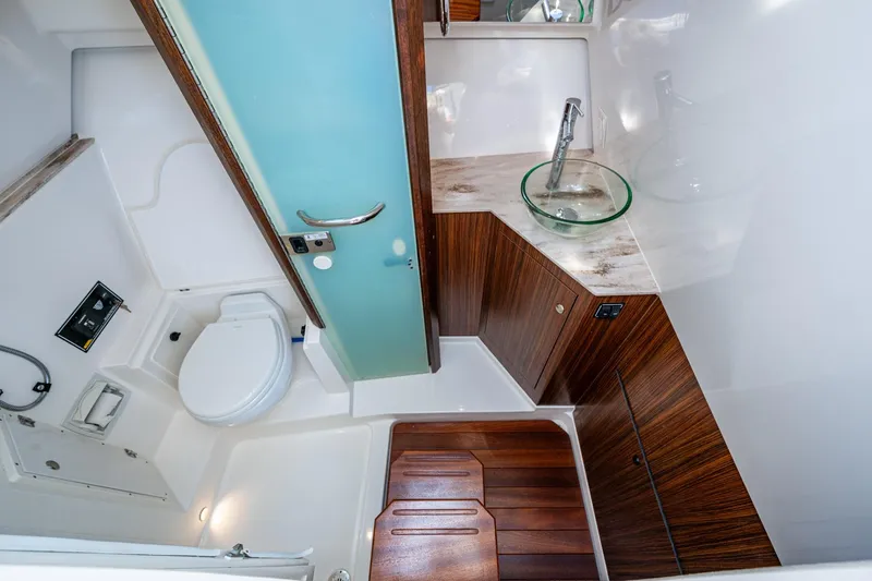  Yacht Photos Pics 2019 Pursuit DC 365 Dual Console boat bathroom with modern design and wooden accents.