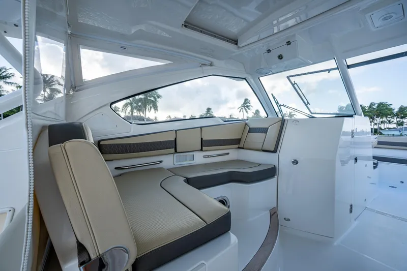 Yacht Photos Pics 2019 Pursuit DC 365 Dual Console interior with beige seating and panoramic windows.