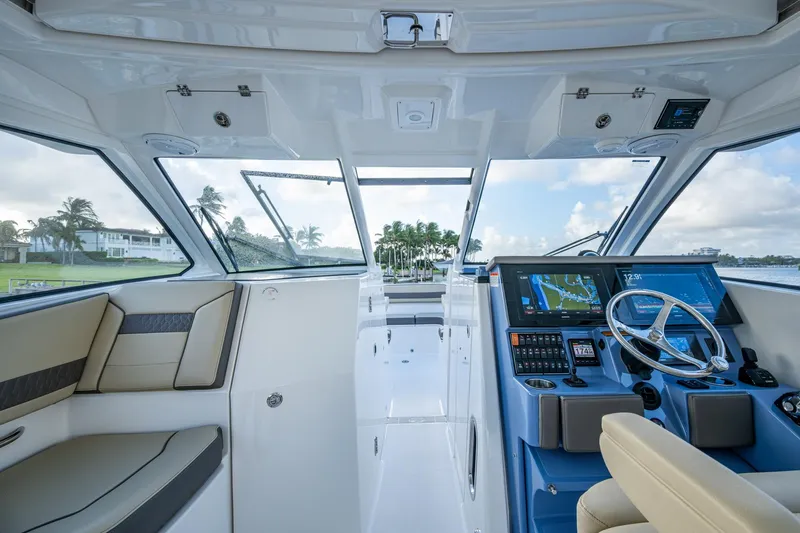  Yacht Photos Pics 2019 Pursuit DC 365 Dual Console interior with modern helm and seating, overlooking scenic waterfront.