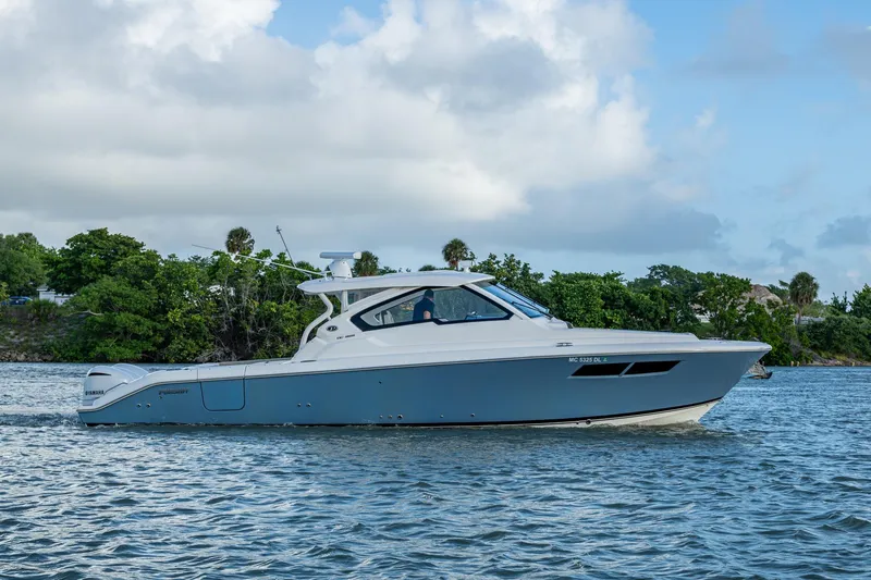  Yacht Photos Pics 2019 Pursuit DC 365 Dual Console boat cruising on a scenic waterway.