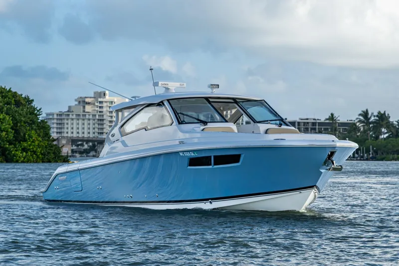  Yacht Photos Pics 2019 Pursuit DC 365 Dual Console boat on water, cityscape background.
