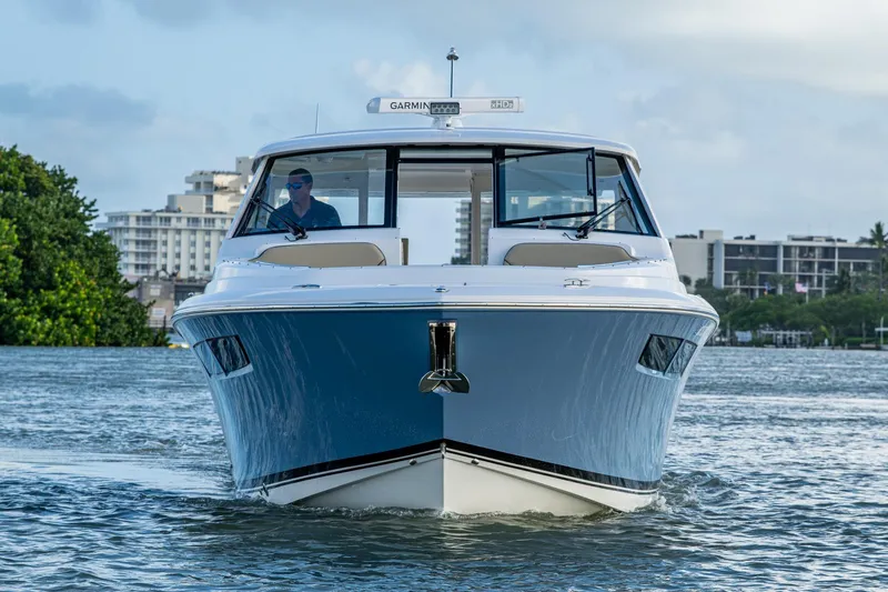  Yacht Photos Pics 2019 Pursuit DC 365 Dual Console boat cruising on water, cityscape background.