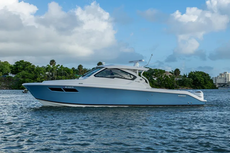  Yacht Photos Pics 2019 Pursuit DC 365 Dual Console boat on calm water, blue sky background.