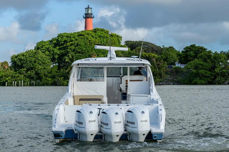  Yacht Photos Pics 2019 Pursuit DC 365 Dual Console boat with triple Yamaha engines near a lighthouse.