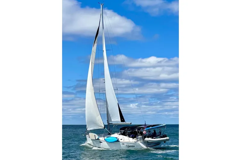Sunniva Yacht Photos Pics Sailing yacht Beneteau Oceanis 46, 2007 model, cruising on open sea under blue sky.