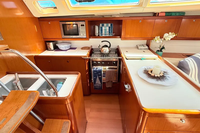 Sunniva Yacht Photos Pics Luxurious 2007 Beneteau Oceanis 46 yacht kitchen with wood cabinetry and modern appliances.