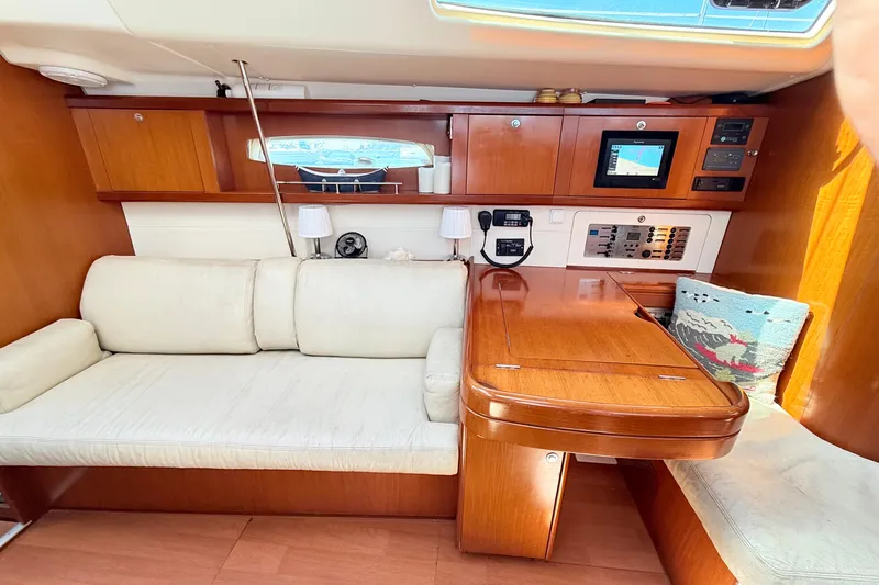 Sunniva Yacht Photos Pics Interior of 2007 Beneteau Oceanis 46 yacht with wooden table and white seating.