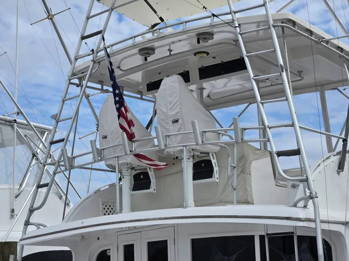  Yacht Photos Pics 1988 Topaz 44 Flybridge with American flag, featuring dual covered seats and ladder.