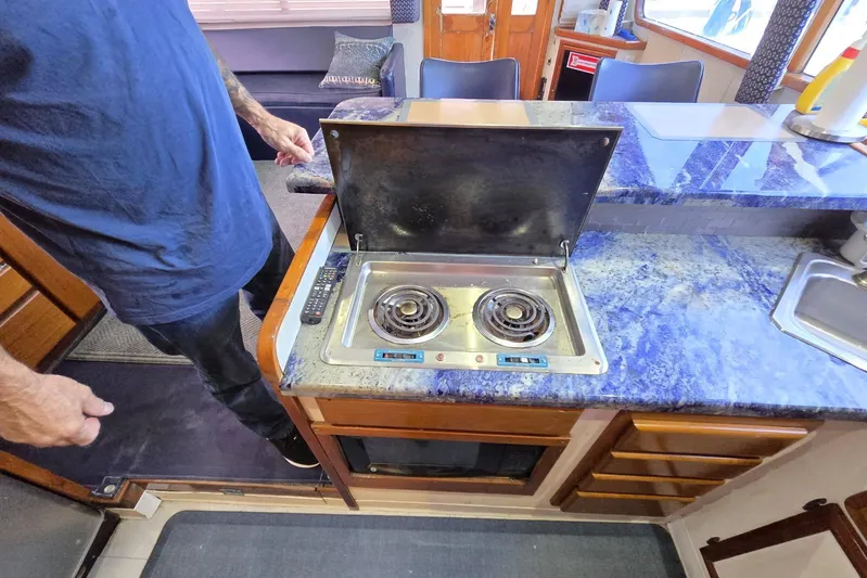  Yacht Photos Pics 1988 Topaz 44 Flybridge yacht kitchen with electric stove and blue countertop.