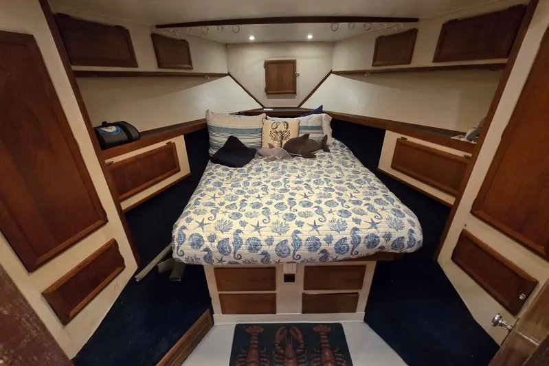  Yacht Photos Pics Cozy cabin interior of 1988 Topaz 44 Flybridge with nautical-themed bedding and wooden accents.