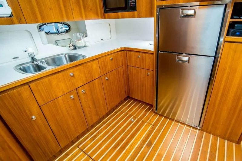 Bluefin Yacht Photos Pics Luxurious Tiara 41 Open 2000 yacht kitchen with wood cabinetry and stainless steel appliances.