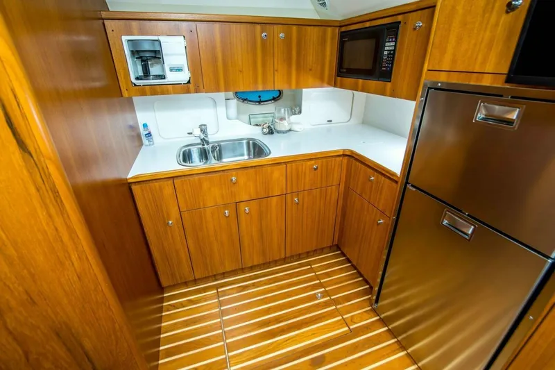 Bluefin Yacht Photos Pics Luxurious galley kitchen in 2000 Tiara 41 Open yacht with wood cabinetry and stainless appliances.