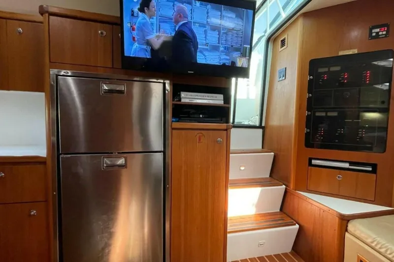 Bluefin Yacht Photos Pics Interior of 2000 Tiara 41 Open yacht with TV, fridge, and control panel.