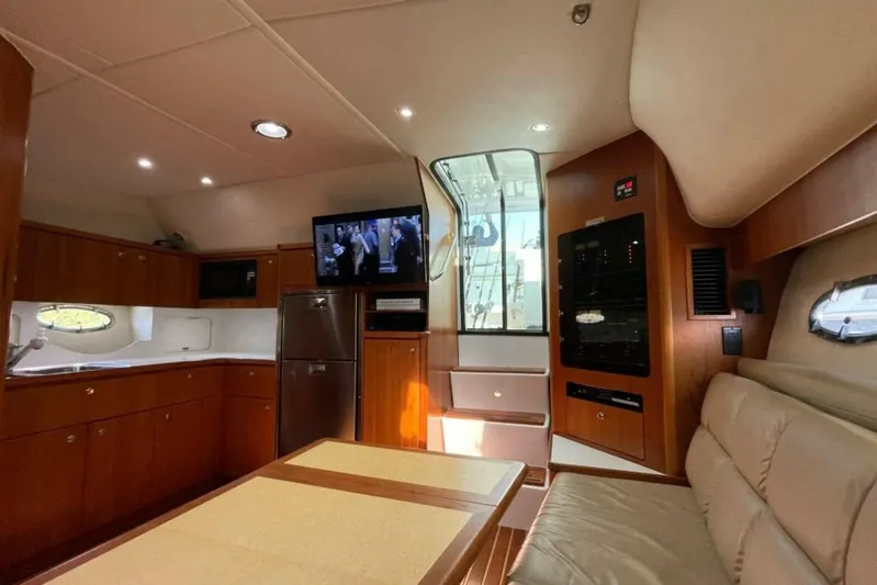 Bluefin Yacht Photos Pics Interior of 2000 Tiara 41 Open yacht with kitchen, seating, and TV.