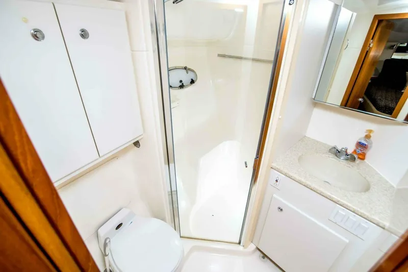 Bluefin Yacht Photos Pics Bathroom interior of 2000 Tiara 41 Open yacht, featuring shower, sink, and toilet.
