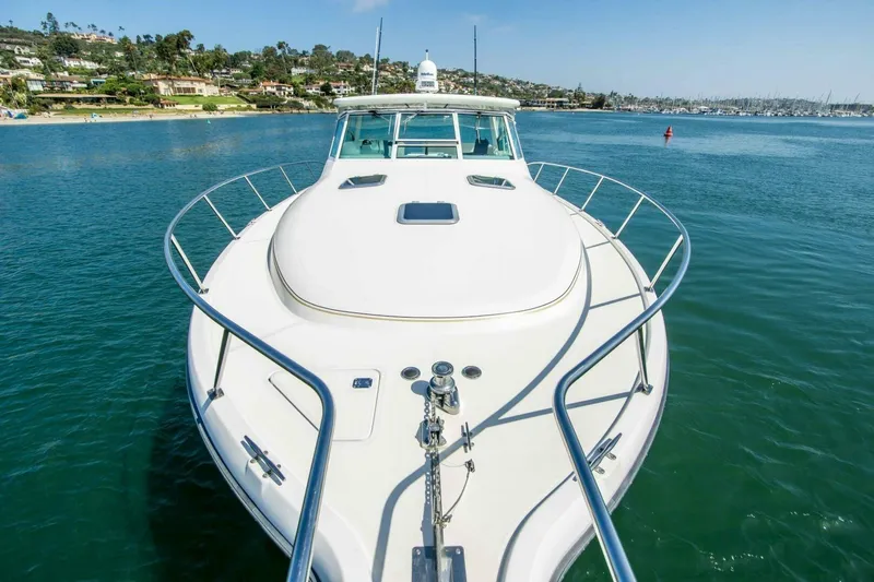 Bluefin Yacht Photos Pics 2000 Tiara 41 Open yacht on calm water, coastal homes in background.