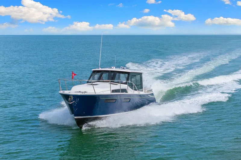 Mjm 42 For Sale Yacht Photos Pics 2024 MJM 42 yacht cruising on open water under a clear blue sky.