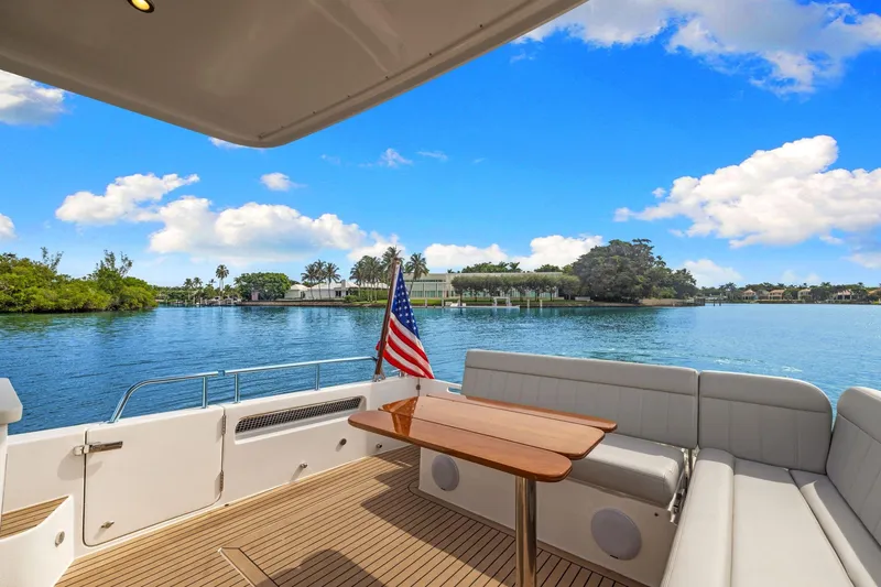 Mjm 42 For Sale Yacht Photos Pics 2024 MJM 42 yacht deck with seating, table, and American flag on a sunny day.