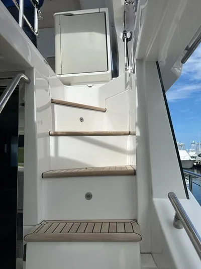  Yacht Photos Pics Staircase on 2019 Azimut 60 Flybridge yacht with wooden steps and white railing.