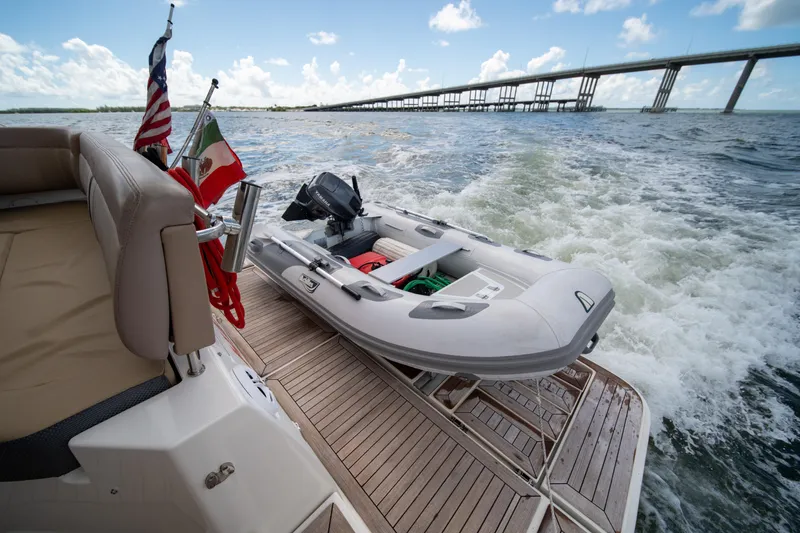  Yacht Photos Pics 2016 Sea Ray 400 Sundancer with inflatable boat on deck, cruising under a bridge.