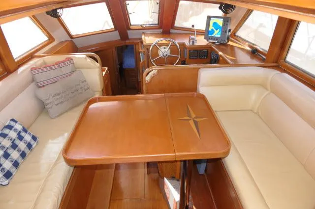 Peregrine Yacht Photos Pics Pilothouse interior of 2002 Tayana 460 Vancouver, featuring wooden table and plush seating.