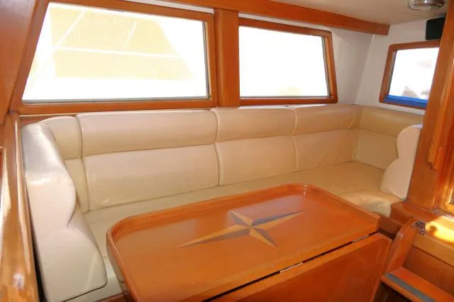 Peregrine Yacht Photos Pics Luxurious interior of 2002 Tayana 460 Vancouver Pilothouse with beige seating and wooden table.
