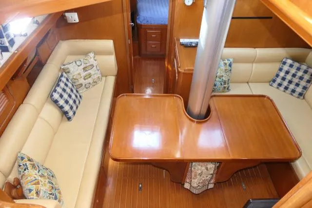 Peregrine Yacht Photos Pics Interior of 2002 Tayana 460 Vancouver Pilothouse with wooden table and beige seating.