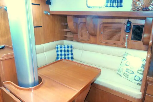 Peregrine Yacht Photos Pics Interior of 2002 Tayana 460 Vancouver Pilothouse with wooden table and cushioned seating.