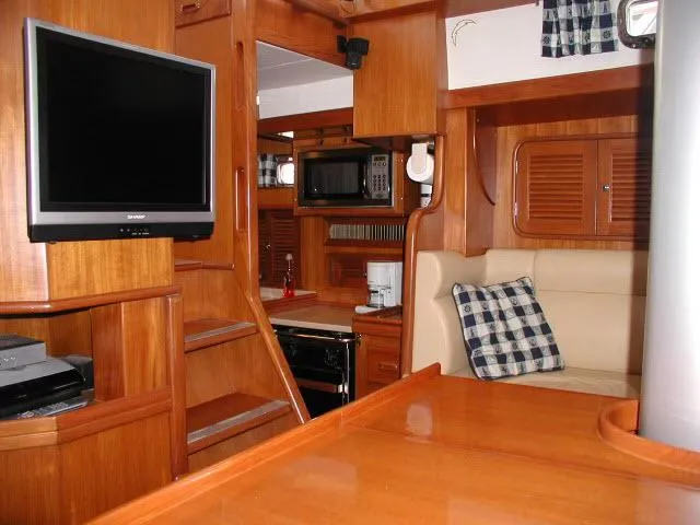 Peregrine Yacht Photos Pics Interior of 2002 Tayana 460 Vancouver Pilothouse with wood finish, TV, and seating area.