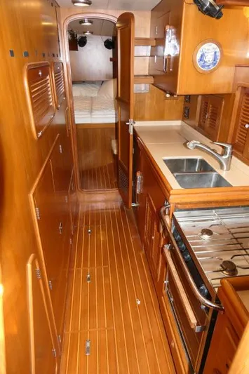 Peregrine Yacht Photos Pics 2002 Tayana 460 Vancouver Pilothouse galley with wood finish, stove, and sink.