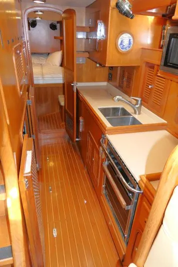 Peregrine Yacht Photos Pics 2002 Tayana 460 Vancouver Pilothouse interior with wood finish, kitchen, and cozy sleeping area.