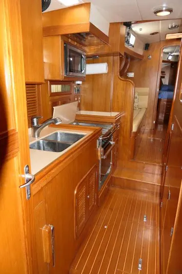 Peregrine Yacht Photos Pics Interior of 2002 Tayana 460 Vancouver Pilothouse with wooden cabinetry and modern kitchen amenities.
