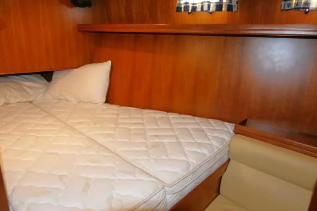 Peregrine Yacht Photos Pics Cozy cabin interior of 2002 Tayana 460 Vancouver Pilothouse with wooden finish and comfortable bedding.