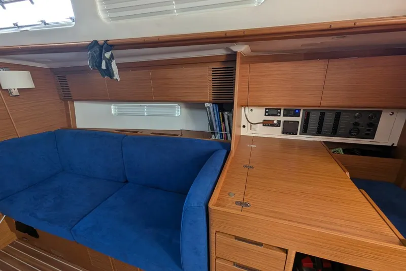 Muchacha De Abril Yacht Photos Pics Interior of 2017 X-Yachts Xc 45 with blue sofa and wooden cabinetry.