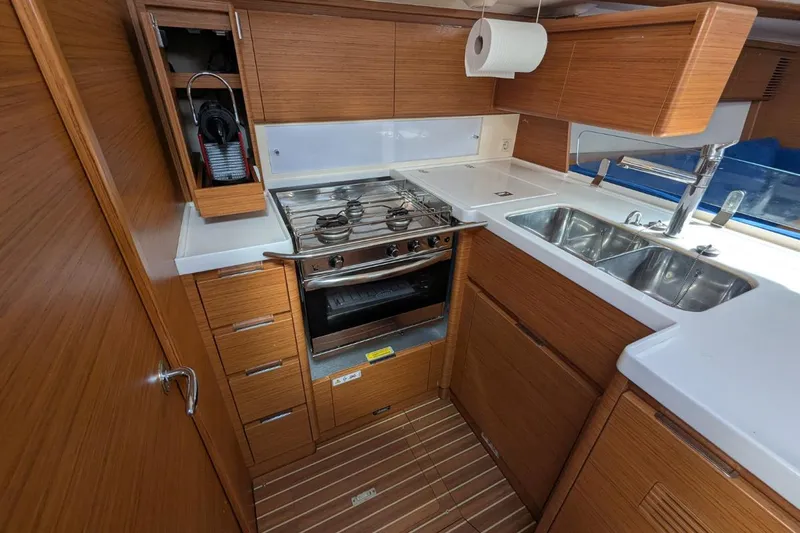 Muchacha De Abril Yacht Photos Pics Modern galley kitchen in 2017 X-Yachts Xc 45 sailboat with wood cabinetry and stainless steel appliances.