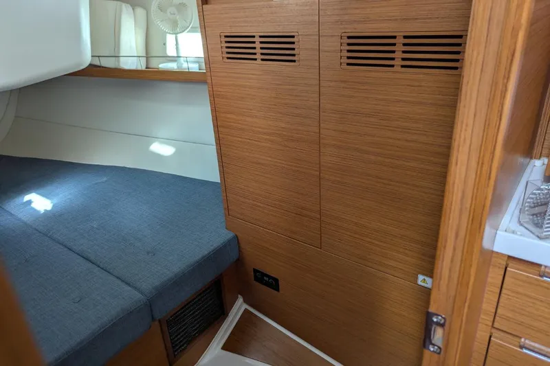 Muchacha De Abril Yacht Photos Pics Interior cabin of 2017 X-Yachts Xc 45 with wooden paneling and blue upholstery.