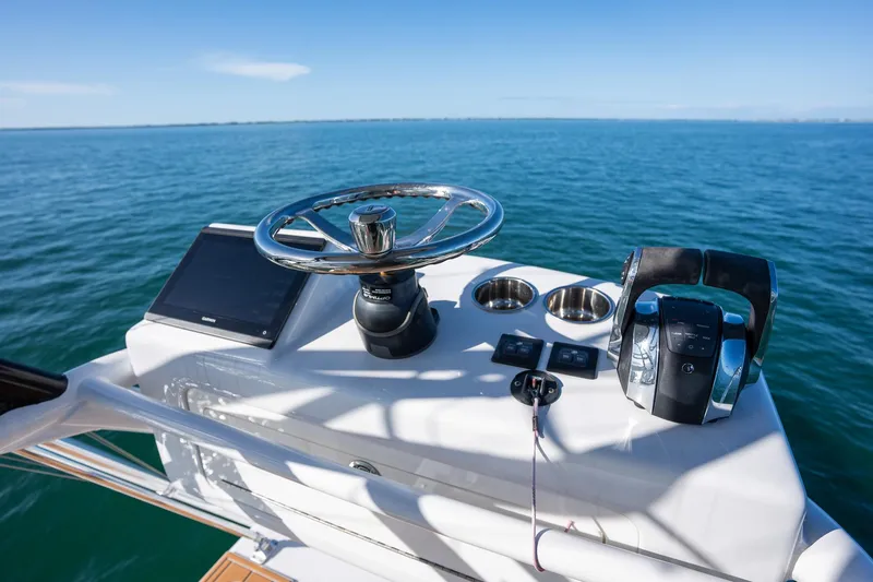  Yacht Photos Pics Freeman 47 boat helm with steering wheel and controls, 2022 model, on open water.