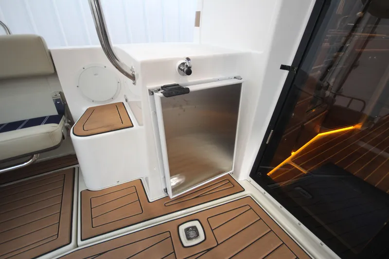 Patrick Mcginty Yacht Photos Pics 2022 Ranger Tugs R-29 Sedan Luxury Edition interior with sleek wood flooring and compact fridge.