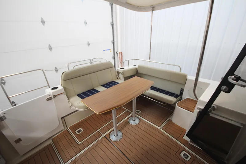 Patrick Mcginty Yacht Photos Pics 2022 Ranger Tugs R-29 Sedan Luxury Edition interior with seating and wooden table.