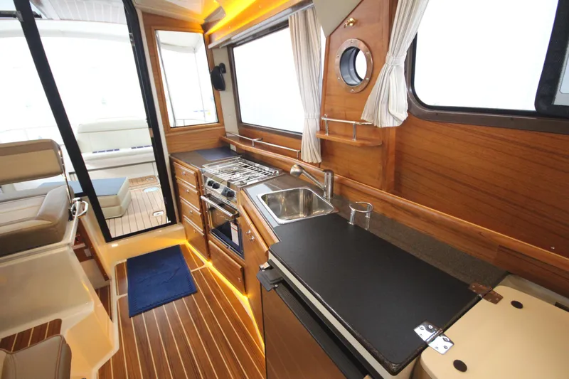 Patrick Mcginty Yacht Photos Pics 2022 Ranger Tugs R-29 Sedan Luxury Edition interior with modern kitchen and wood finish.