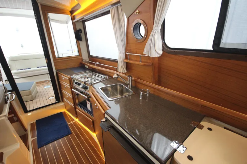 Patrick Mcginty Yacht Photos Pics 2022 Ranger Tugs R-29 Sedan Luxury Edition interior with modern kitchen and wood finish.